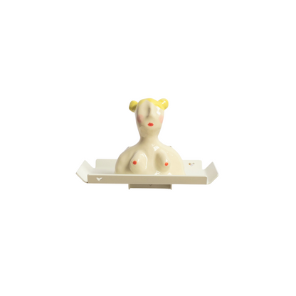 Grijze tray van Studio Mippe met wandbeugel. Op het wandplankje staat een keramieken buste van een vrouw met geel haar en knotjes
